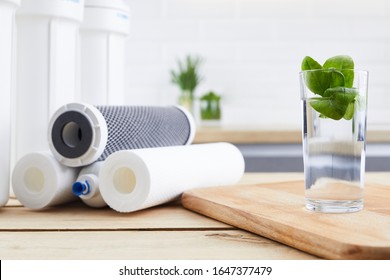 A Glass Of Clean Water With Osmosis Filter And Cartridges In A Kitchen Interior. Concept Household Filtration System.