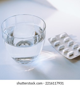 Glass Of Clean Water In Rays Of Light And Pills On Pills. Aspirin Pills, Paracetamol, Ibuprofen And Glass Of Water, Lifestyle, Illness, Health