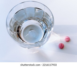 Glass Of Clean Water In Rays Of Light And Pills On Pills. Aspirin Pills, Paracetamol, Ibuprofen And Glass Of Water, Lifestyle, Illness, Health