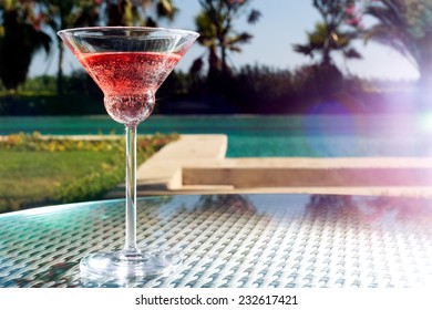 Glass of cocktail on the glass table in outdoor resort bar