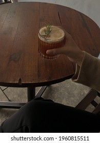 A Glass Of Coffee Mocktail With Rosemary Garnish