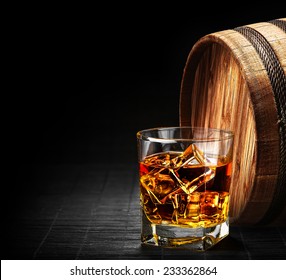 Glass of cognac on the vintage wooden barrel 