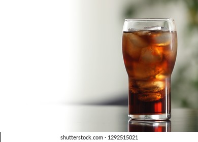 Glass of cola with ice on table against blurred background. Space for text - Shutterstock ID 1292515021