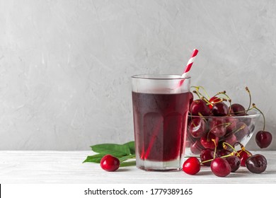 Glass Of Cold Cherry Juice With A Straw And Fresh Berries On White Background With Copy Space. Refreshment Summer Drink