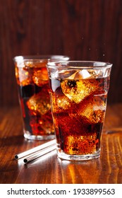 glass of cold cola soft drink with ice on wooden background