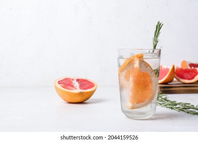 Glass Of Cold Gin Tonic And Grapefruit Slices On Light Background