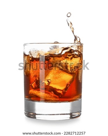 Glass of cold rum with splashes on white background