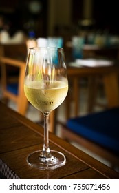 Glass With Cold White Wine On Wooden Table At Restaurant Interior, Nobody