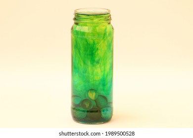 Glass Container With Colored Liquids In Fluid Movements.