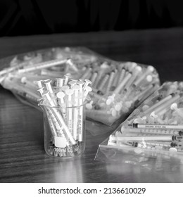 Glass Container Filled With Medical Grade Syringes On Metal Lab Table Black Background