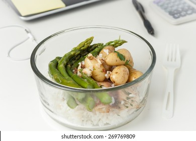 A Glass Container With Lunch With Leftovers On A Desk At Work