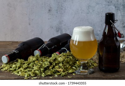 Glass Of Craft Pale Ale With Beer Growlers And Green Dry Hops. Home Brewing. Copy Space.