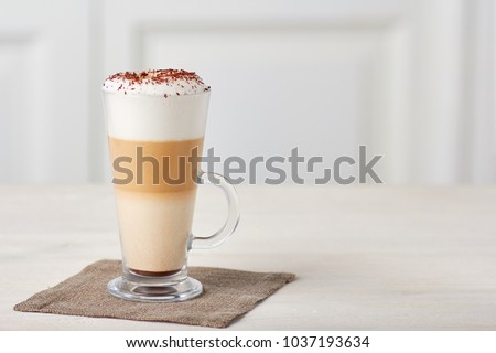 Glass cup of coffee latte on wooden table