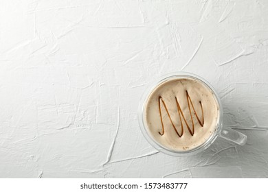 Glass Cup Of Foamy Latte With Caramel On White Background, Top View