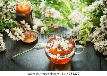 Cup with acacia blossoms Tea with spoon and honey