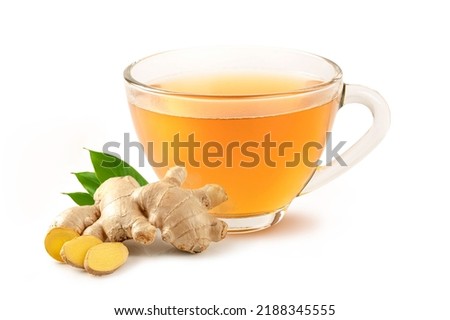 Glass cup of hot ginger tea with ginger root and slices isolated on white background.