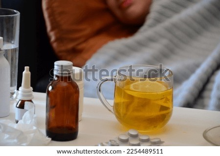 A glass cup of natural tea with ginger, lemon, mint and honey. . Products for the treatment of common cold - lemon, ginger, chamomile tea. Vitamin natural drink.  all kinds of pills and medicines.