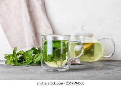 Glass cup of tasty mint tea on table