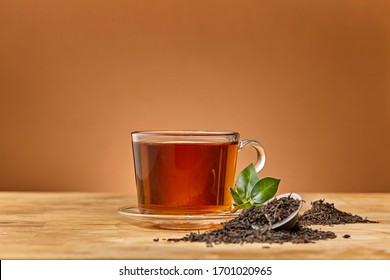 Glass cup of tea brown background. Close up.