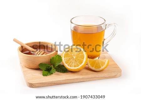 Glass cup of tea with honey , lemon and mint on white background.