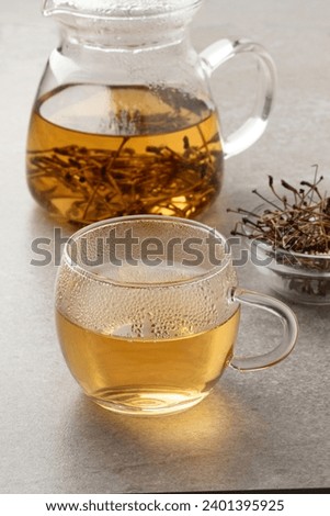 Glass cup with tea made from dried cherry stalks close up  