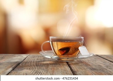 Glass Cup Of Tea On Wooden Table And Blurred Color Background