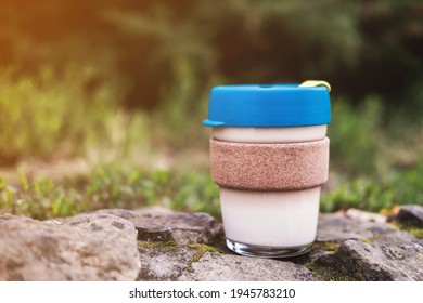 Glass Cup For To-go Coffee Or Tea With Bamboo Hot Drink Holder Stands On Stone Outdoor. Environmental Reusable Mug. Conscious Consumption.