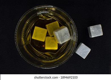 Glass Cup With Whiskey And Stone Cubes For Cooling On A Background Of Black Velvet Fabric. Set For A Strong Alcoholic Drink. View From Above. Close-up. Selective Focus. Artificial Grain.