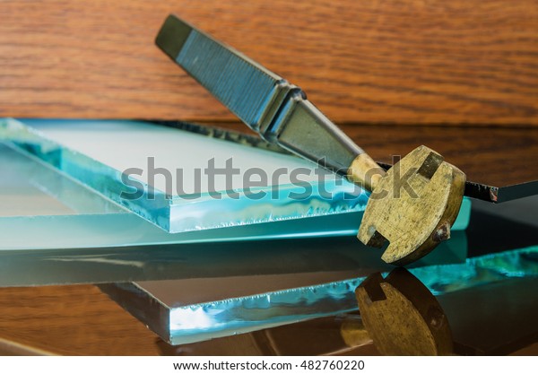 glass and
glass cutter closeup on wooden
background