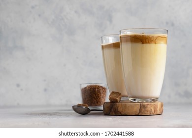 Glass With Dalgona Frothy Coffee. Trend Korean Drink With Coffee Foam On Light Grey Stone Background. 