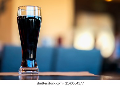 Glass Of Dark Beer In Bar Or In Pub Close Up. Real Scene. Concept Of Beer Culture, Craft Brewery, Uniqueness Of Beer Grades, Meeting Of Low Alcohol Beverage Lovers. Copy Space