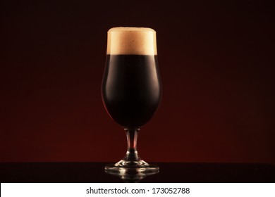 Glass Of Dark Beer On Brown Background 