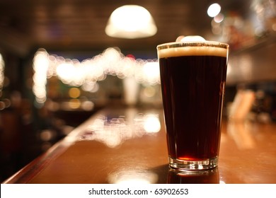 Glass Of Dark Beer On The Counter.