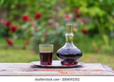 Glass Decanter And Glass With Red Wine In The Summer Garden Background On Wooden Table , Close Up