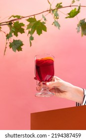 Glass With Delicious Aromatic Cocktail, Mulled Wine With Orange Slice And Cinnamon Stick Isolated Over Pink Background. Concept Of Taste, Drink, Healthy Ingredients, Seasonal Drink. Copy Space For