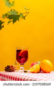 Glass With Delicious Aromatic Cocktail, Mulled Wine With Orange Slice And Cinnamon Stick Isolated On Yellow Background. Concept Of Taste, Drink, Healthy Ingredients, Seasonal Drink. Copy Space For