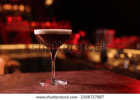 Glass of delicious Espresso Martini on bar counter, space for text. Alcoholic cocktail