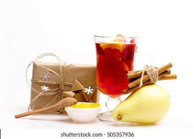 Glass Of Delicious Glintwein Or Mulled Hot Wine, Gift Wrapped In Craft Paper With Bow With Cinnamon, Honey And Pear Isolated On White Background