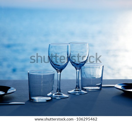 Glass dish cups and glasses on blue sea background