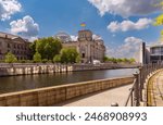 Glass dome and waving German national flags on the Reichstag building. Berlin.