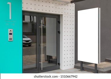 Glass Door - Entrance To Apartment Building With Blank Advertisement Banner Near It