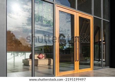 Glass door entrance to a large apartment hotel, the material is wood and steel, beautifully decorated.