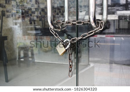 The glass door was locked with padlocks and chains.Locked glass door with chain