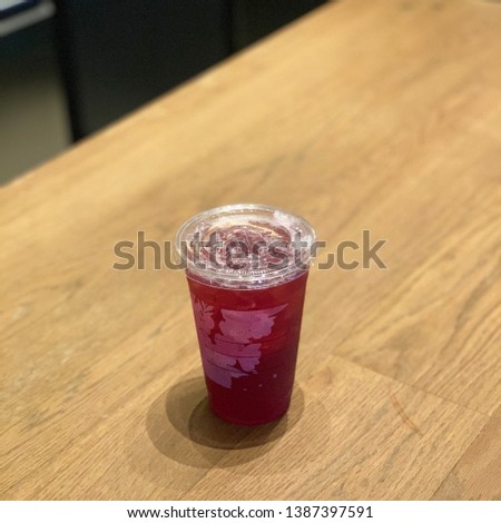 A glass of drink. Iced Shaken Hibiscus Tea with Pomegranate Pearls on wood table background with copy space. 