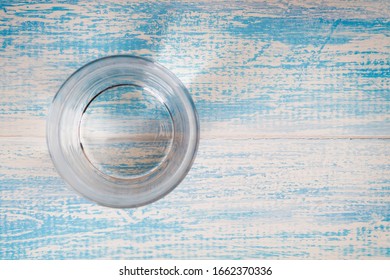 Glass Of Drinking Water On A Blue Wooden Background Top View. Freash Water Cup Overhead.