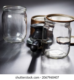 Glass Empty Bottles With Canning Tools Close Up, On Black Background.