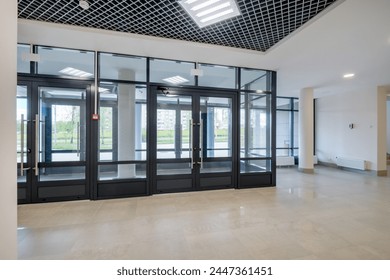 Glass entrance doors to a modern spacious office, view from inside the room - Powered by Shutterstock