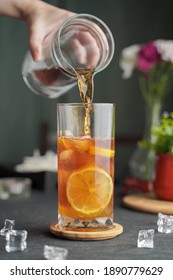 Glass of espresso with lemon juice and fresh sliced lemon on wooden table and copy space, Summer Cocktail, Cold brew coffee or black tea. (close up, selective focus),Pouring cold drink.