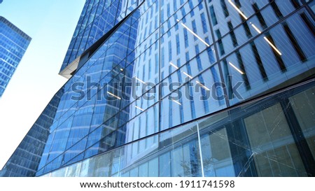 Glass facade of the buildings with a blue sky. Skyscrapers in the business city center.. Background of modern glass buildings. 