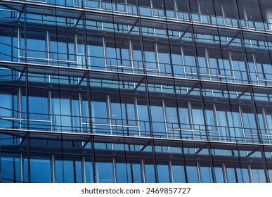 Glass facade of a modern building with repeating windows and metal framework. - Powered by Shutterstock